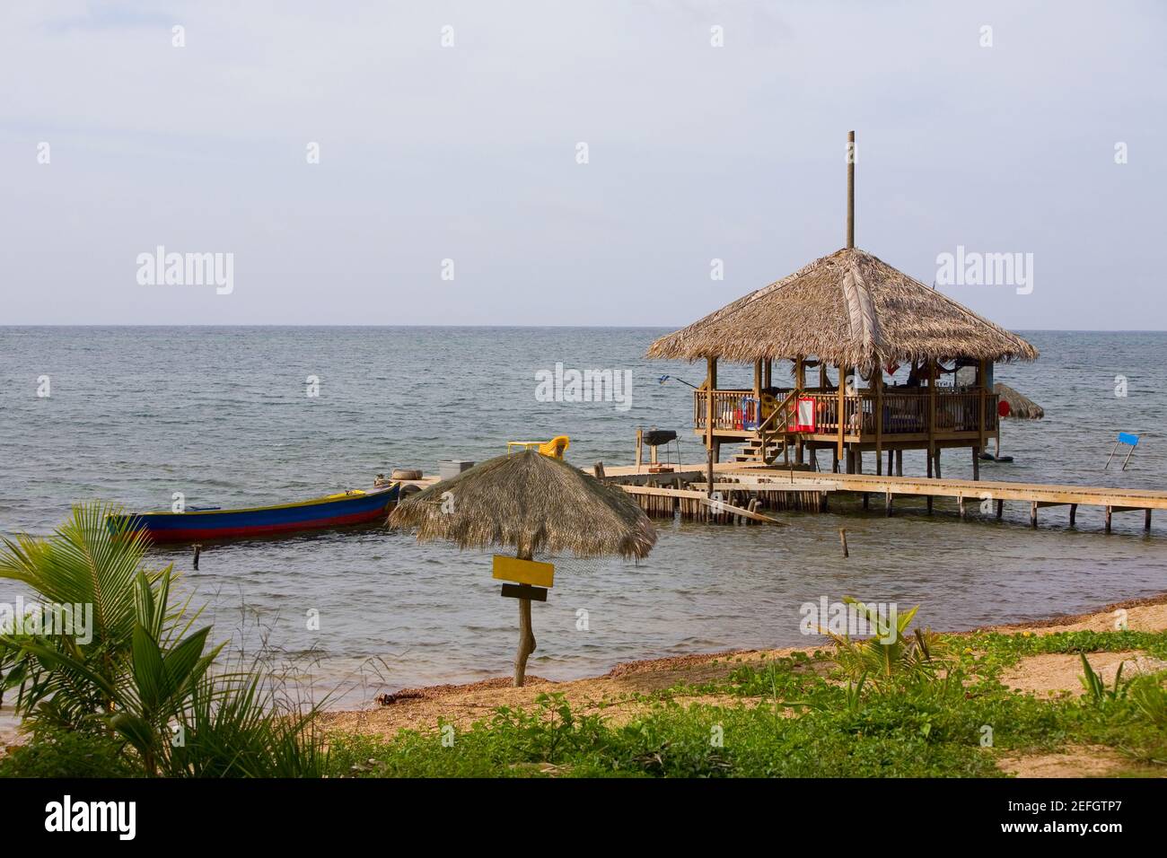 Capanna sulla spiaggia sul molo, Paya Bay Resort, Roatan, Bay Islands, Honduras Foto Stock