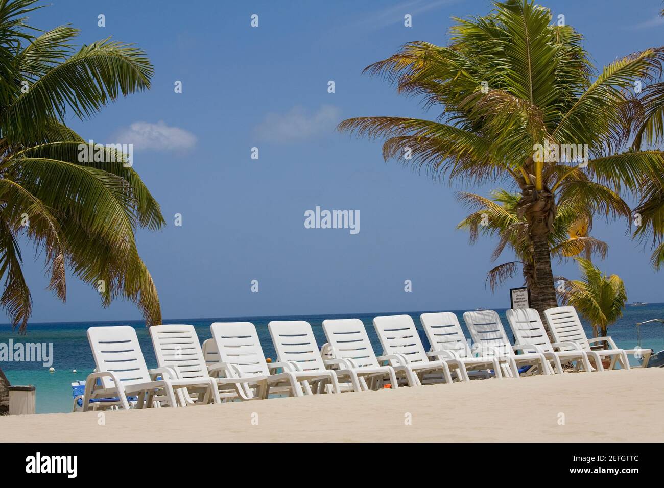 Sedie a sdraio sulla spiaggia, Roatan, Bay Islands, Honduras Foto Stock