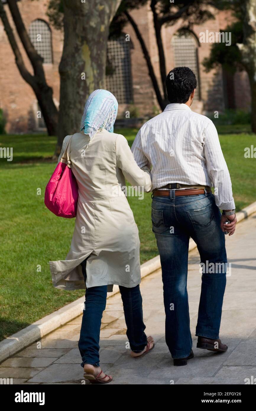 Vista posteriore di una coppia che cammina con il braccio in braccio, Istanbul, Turchia Foto Stock