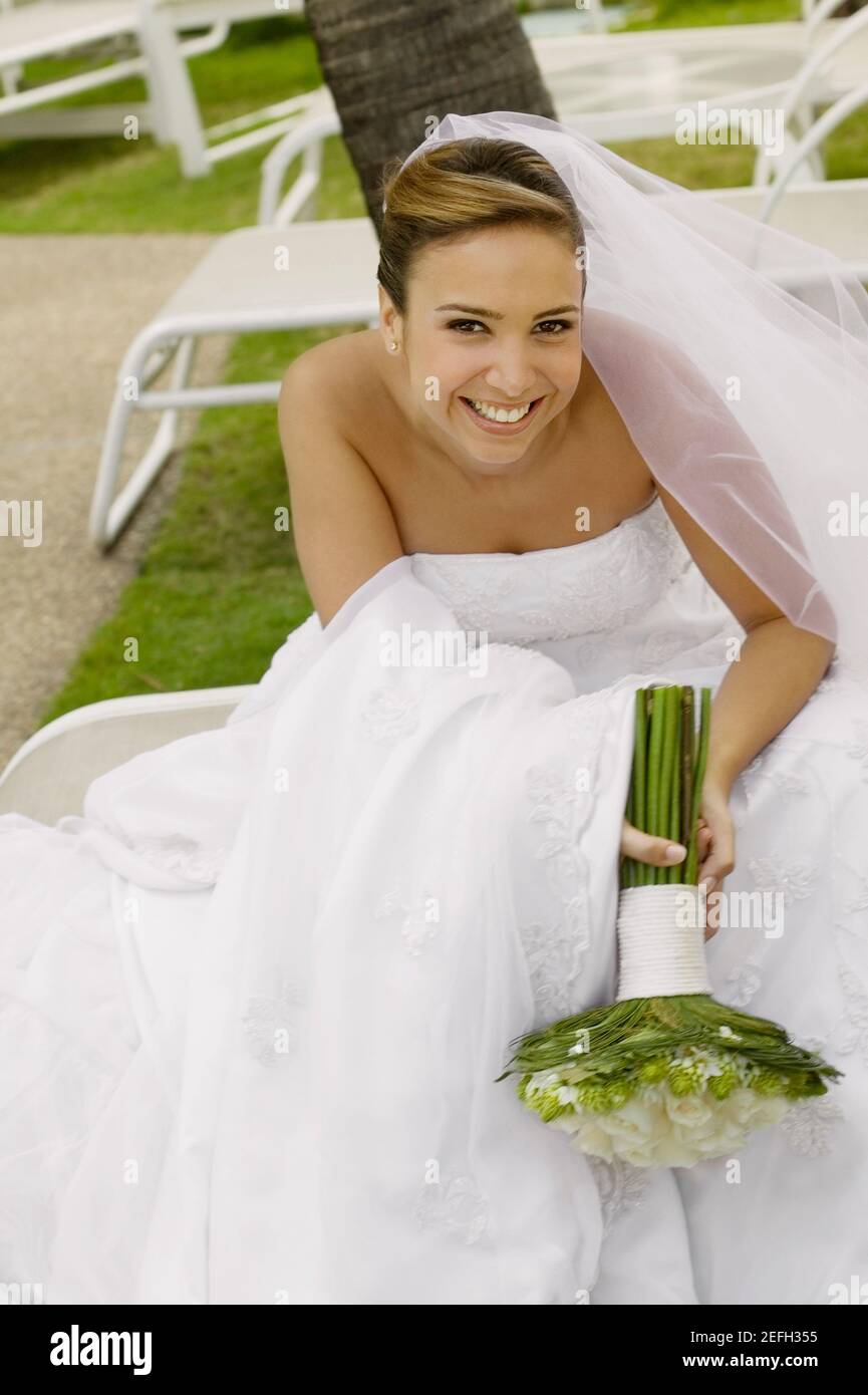 Ritratto di una sposa tenendo un mazzo di fiori e sorridente Foto Stock