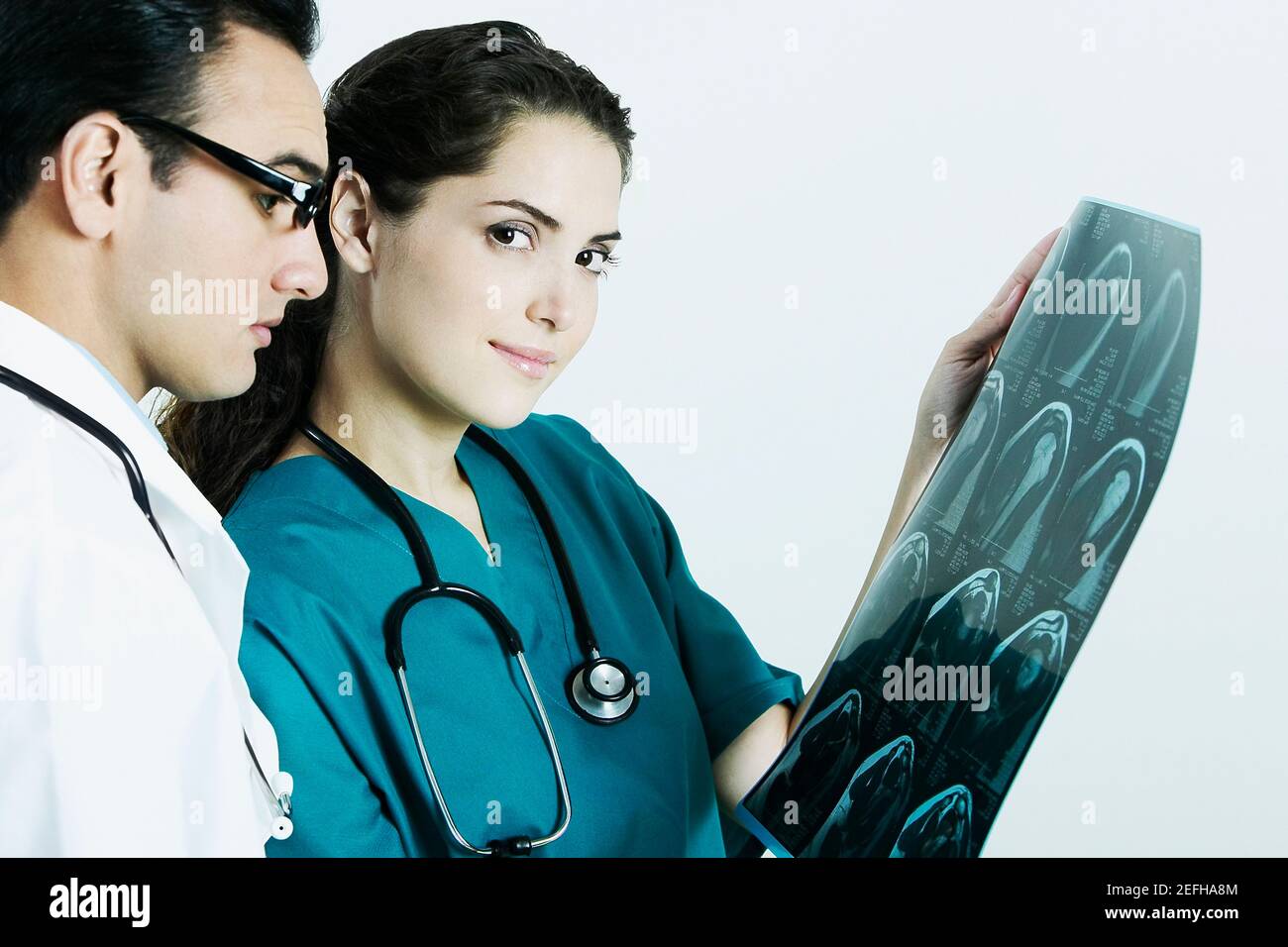 Ritratto di una dottoressa che tiene un X Ray con un medico maschile accanto a lei Foto Stock