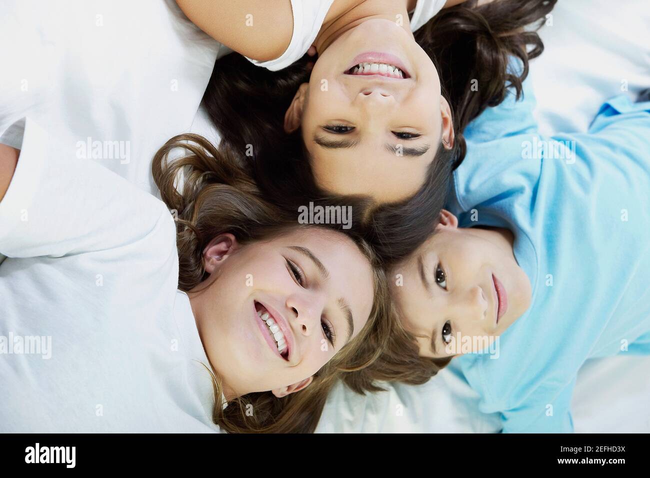 Primo piano di un ragazzo e delle sue due sorelle su cui giace il letto Foto Stock