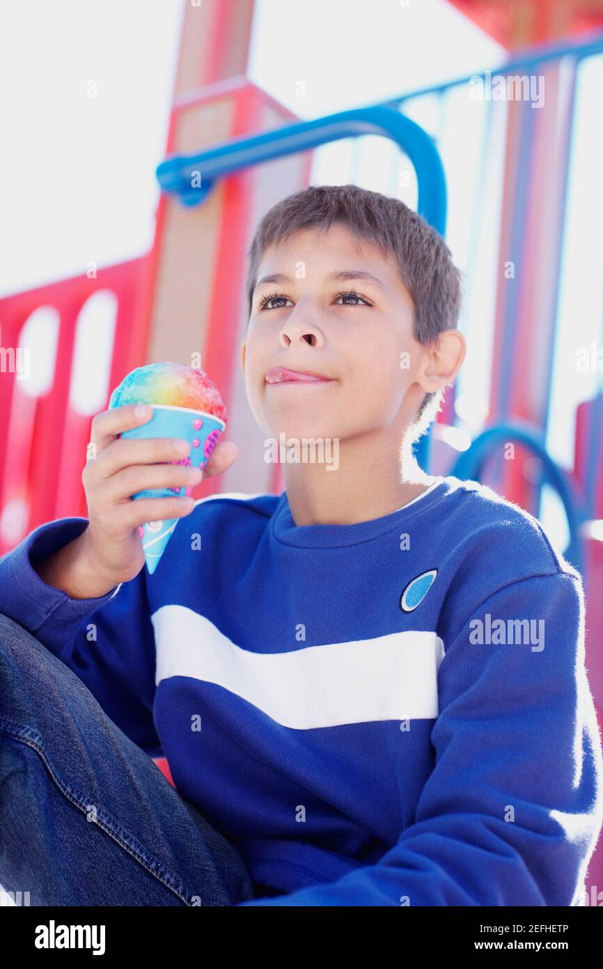 Primo piano di un ragazzo adolescente che tiene un cono gelato Foto Stock