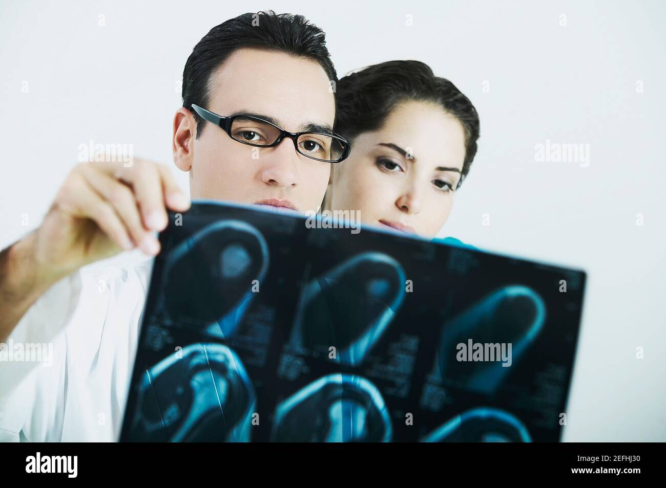 Medico di sesso maschile e medico di sesso femminile che esamina un X Ray Foto Stock