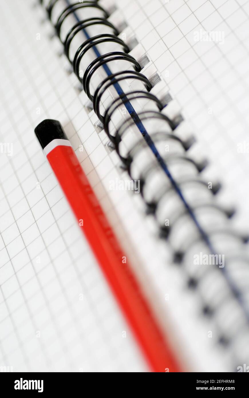 Primo piano di una matita su un libro a spirale aperto Foto Stock
