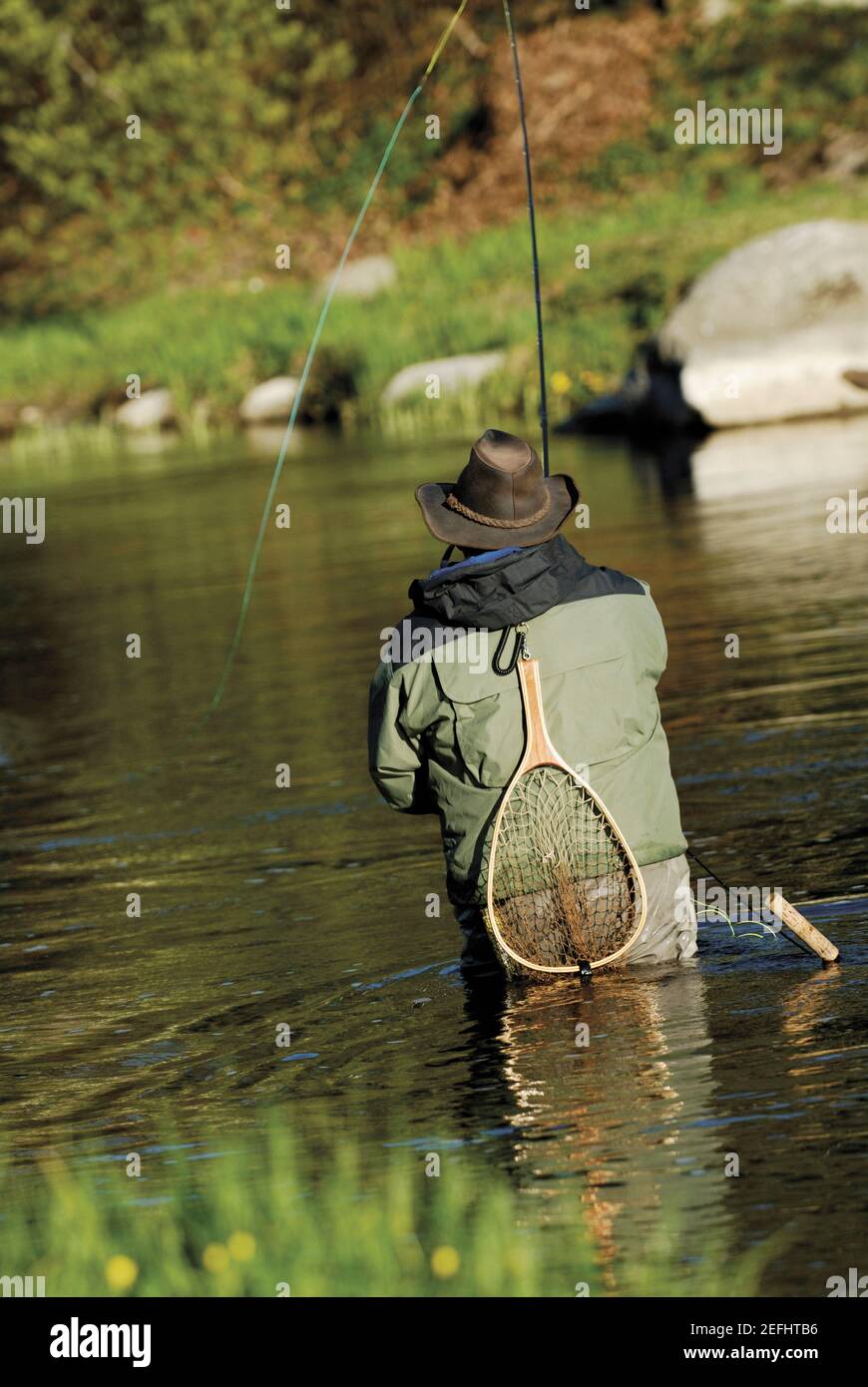 Vista posteriore di un uomo la pesca nel fiume Foto Stock