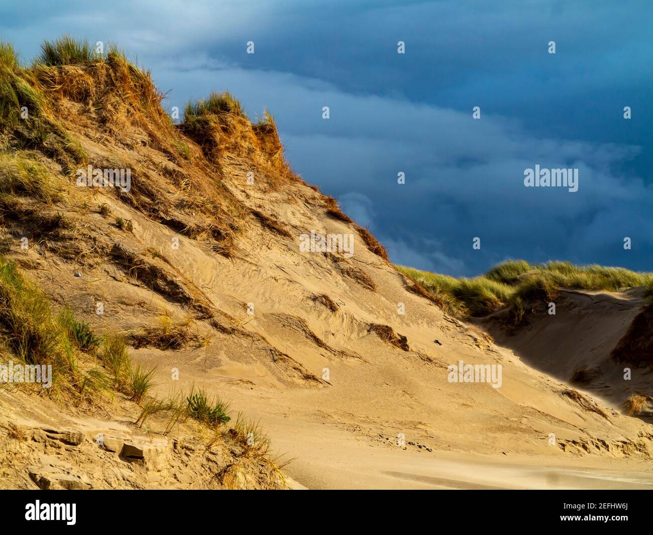 Dune di sabbia sulla spiaggia di Morfa Dyffryn tra Barmouth e Harlech a Gwynedd sulla costa nord occidentale del Galles con cielo tempestoso sopra. Foto Stock