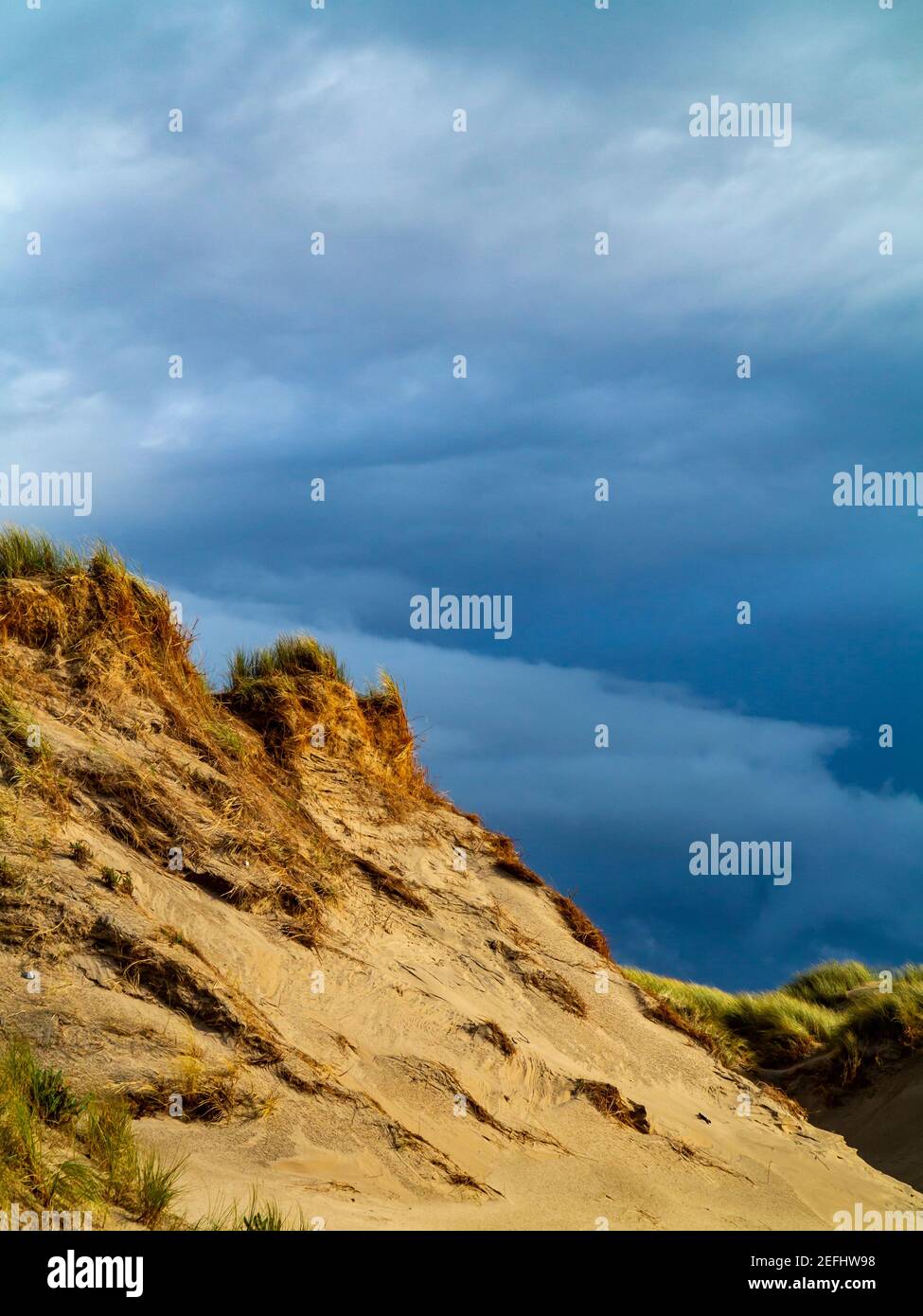 Dune di sabbia sulla spiaggia di Morfa Dyffryn tra Barmouth e Harlech a Gwynedd sulla costa nord occidentale del Galles con cielo tempestoso sopra. Foto Stock