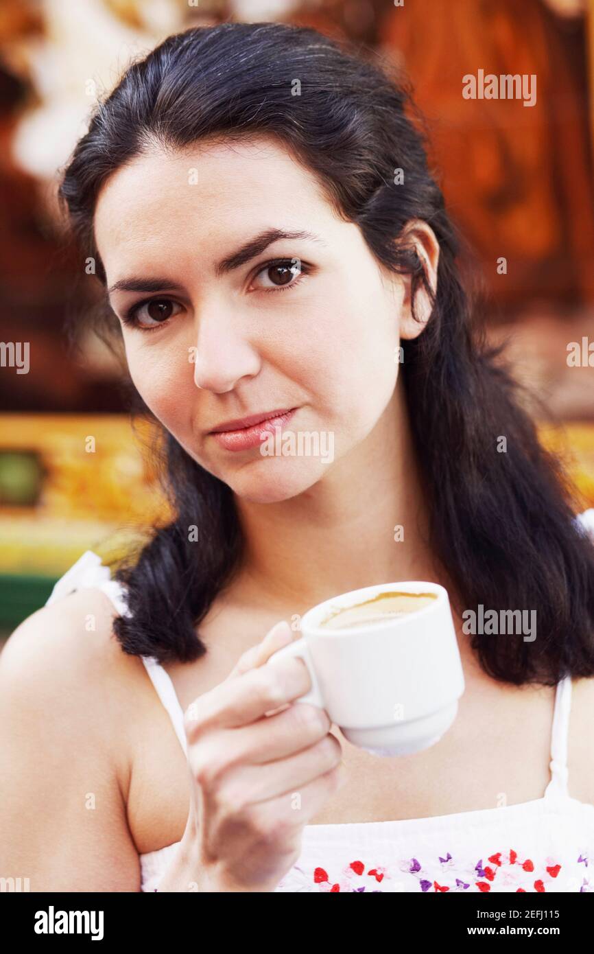 Ritratto di una metà donna adulta tenendo una tazza di caffè Foto Stock