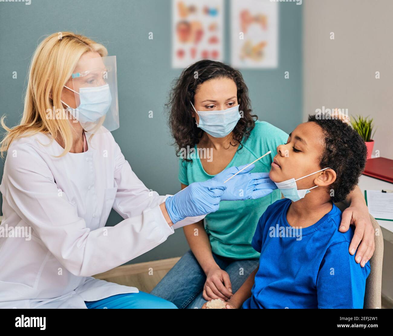 Ragazzo afroamericano con sua madre durante il test PCR di COVID-19 in un laboratorio medico. Medico che prende un tampone nasale per il campione di coronavirus Foto Stock