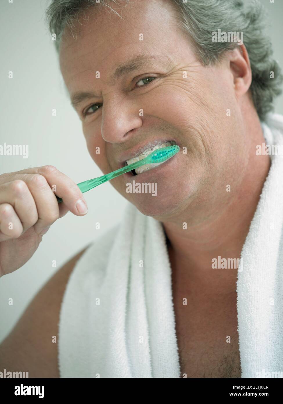 Ritratto di un uomo maturo spazzolando i suoi denti Foto Stock