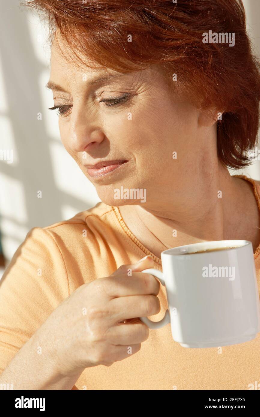 Primo piano di una donna anziana che tiene una tazza di caffè Foto Stock