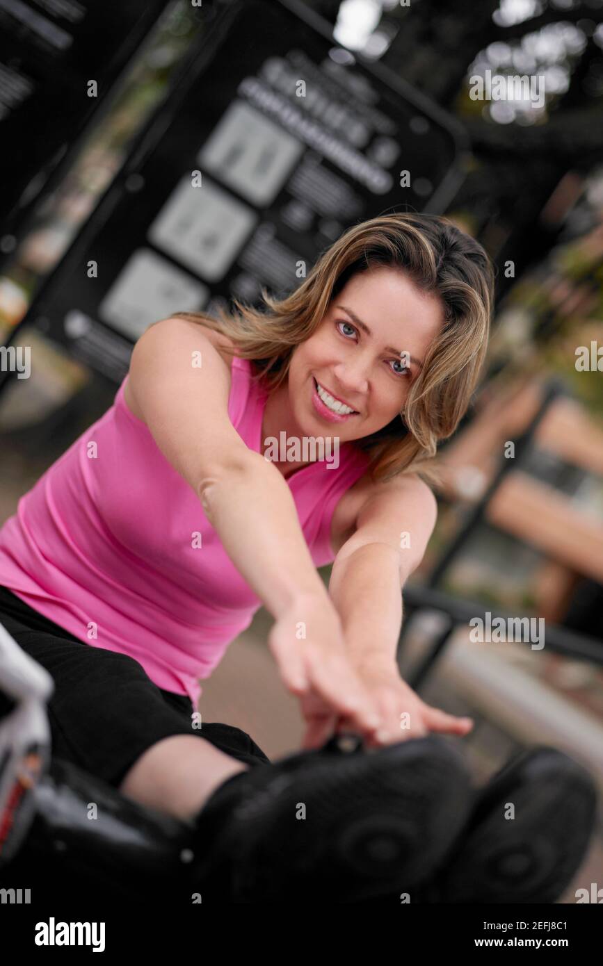 Ritratto di una giovane donna che si siede e la tocca dita dei piedi Foto Stock