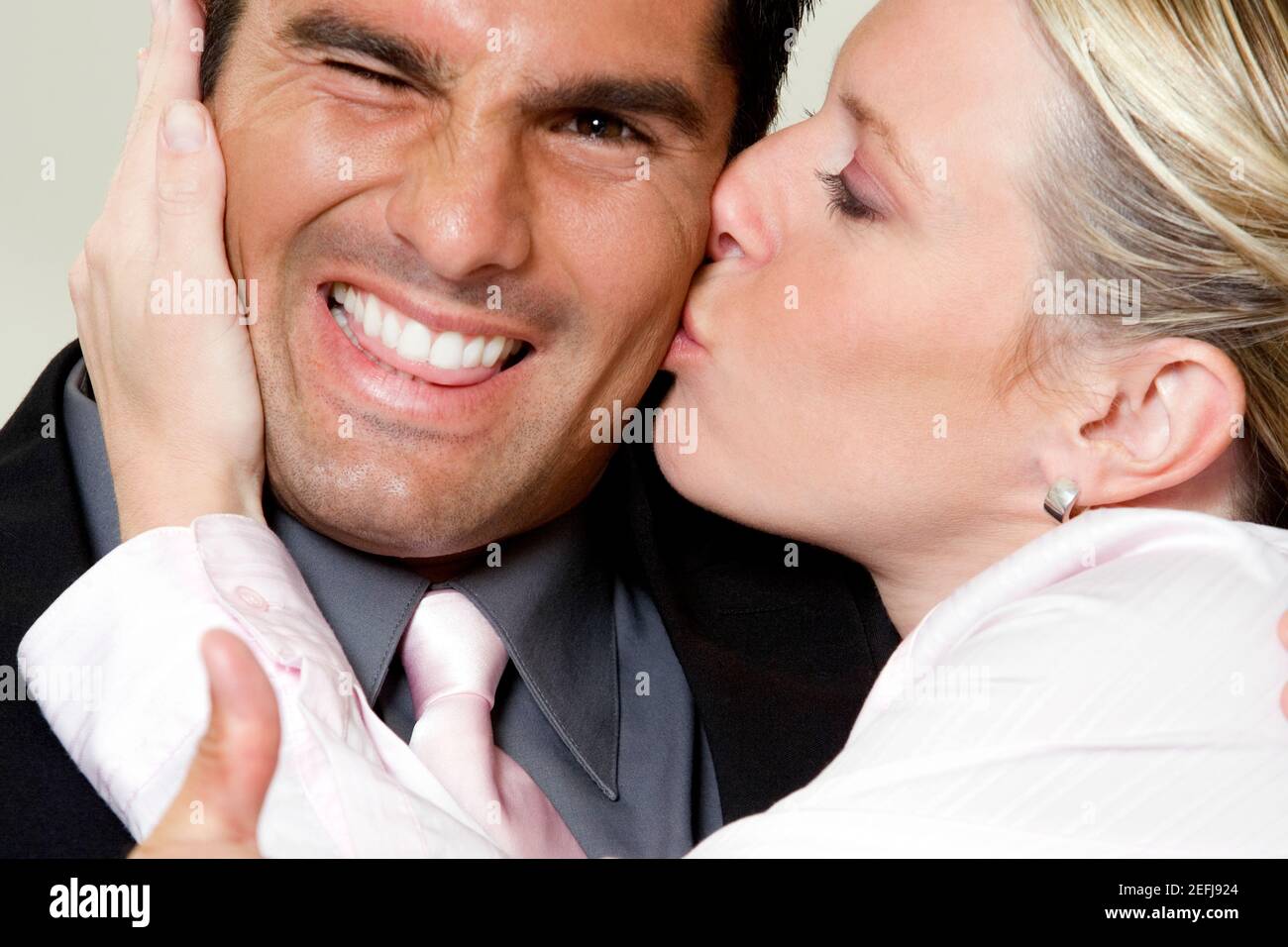 Close-up di una imprenditrice baciando un imprenditore Foto Stock