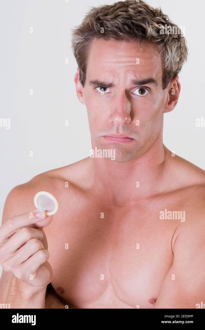 Ritratto di un giovane che detiene un preservativo Foto Stock
