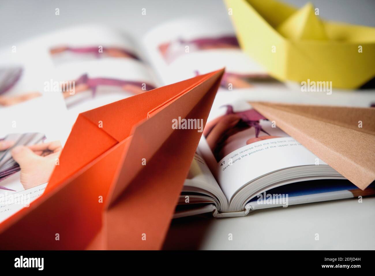 Primo piano di un libro con barche di carta Foto Stock