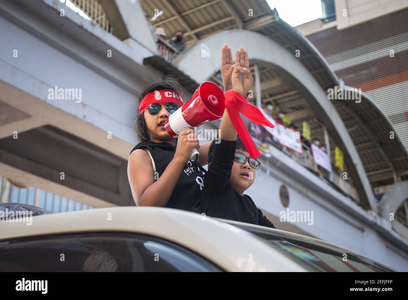 I bambini che fanno il saluto a tre dita mentre si parla di un megafono, durante una dimostrazione contro il colpo di stato militare nel centro di Yangon.il consigliere di Stato militare detenuto da Myanmar Aung San Suu Kyi il 01 febbraio, 2021 e ha dichiarato uno stato di emergenza mentre coglie il potere nel paese per un anno dopo aver perso le elezioni contro la Lega nazionale per la democrazia (NLD). Foto Stock