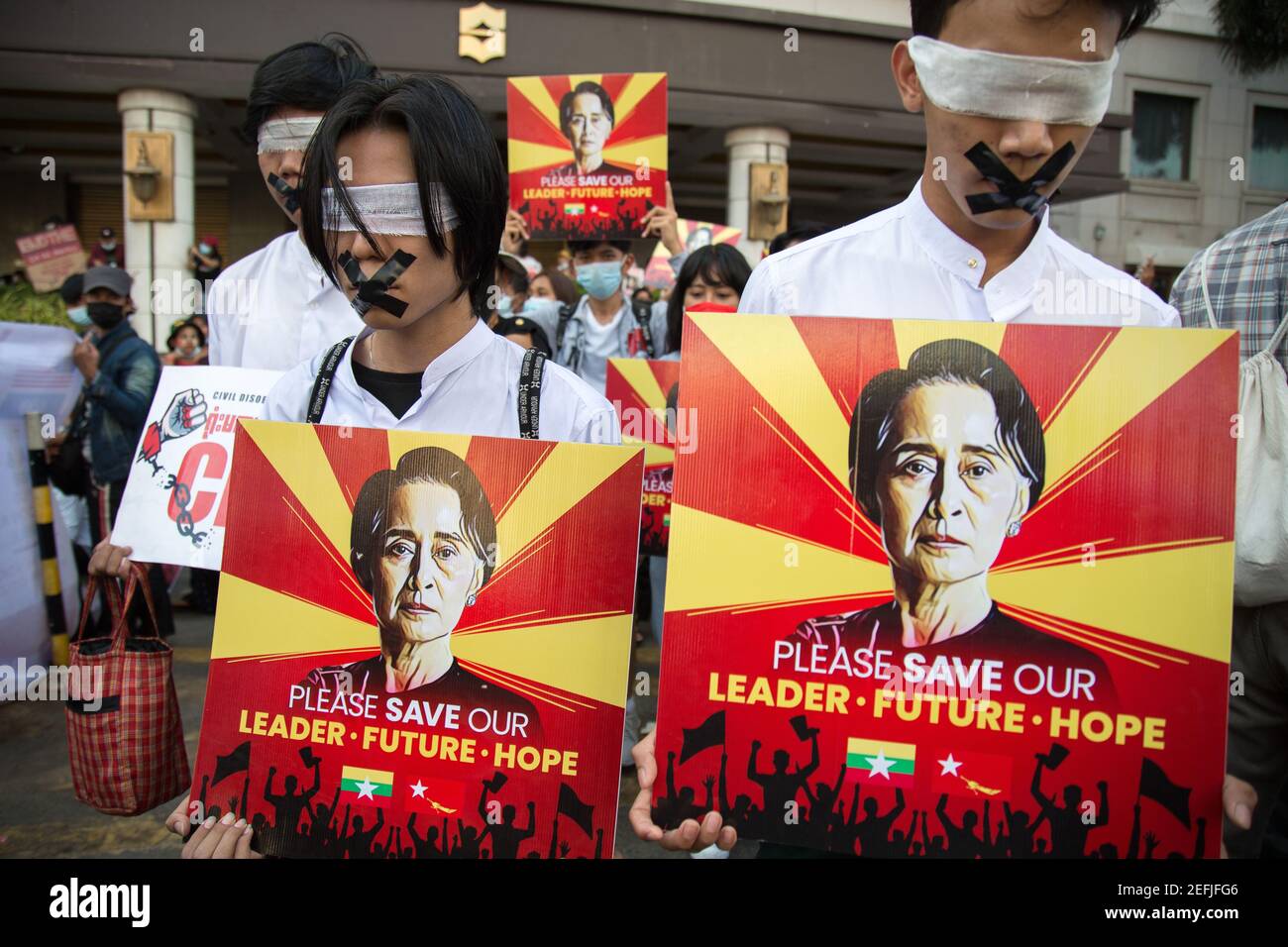 I manifestanti hanno tappato e chiuso i cartelli pro-Aung San Suu Kyi, durante una manifestazione contro il colpo di stato militare nel centro di Yangon.il consigliere di Stato militare di Myanmar, detenuto il 01 febbraio da Aung San Suu Kyi, 2021 e ha dichiarato uno stato di emergenza mentre coglie il potere nel paese per un anno dopo aver perso le elezioni contro la Lega nazionale per la democrazia (NLD). Foto Stock