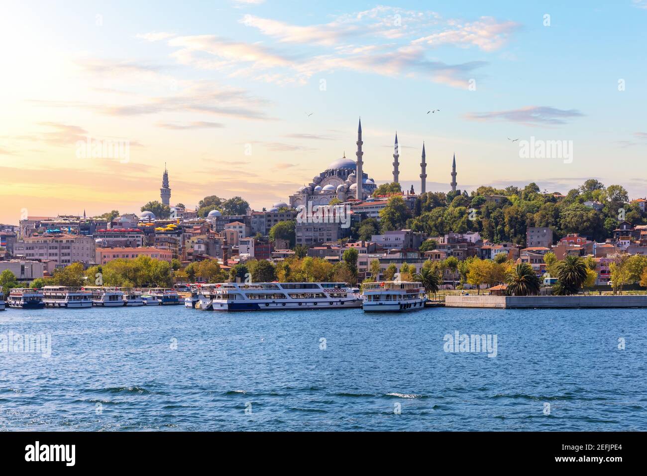 Molo di Eminonu vicino alla Moschea Suleymaniye a Istanbul, vista dal Bosforo al tramonto Foto Stock