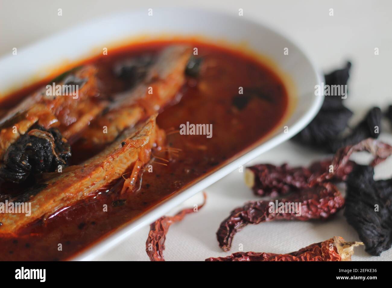 Il curry di sardine è un curry centrale tradizionale del Kerala anche conosciuto come curry di mathi. Scatto su sfondo bianco. Foto Stock