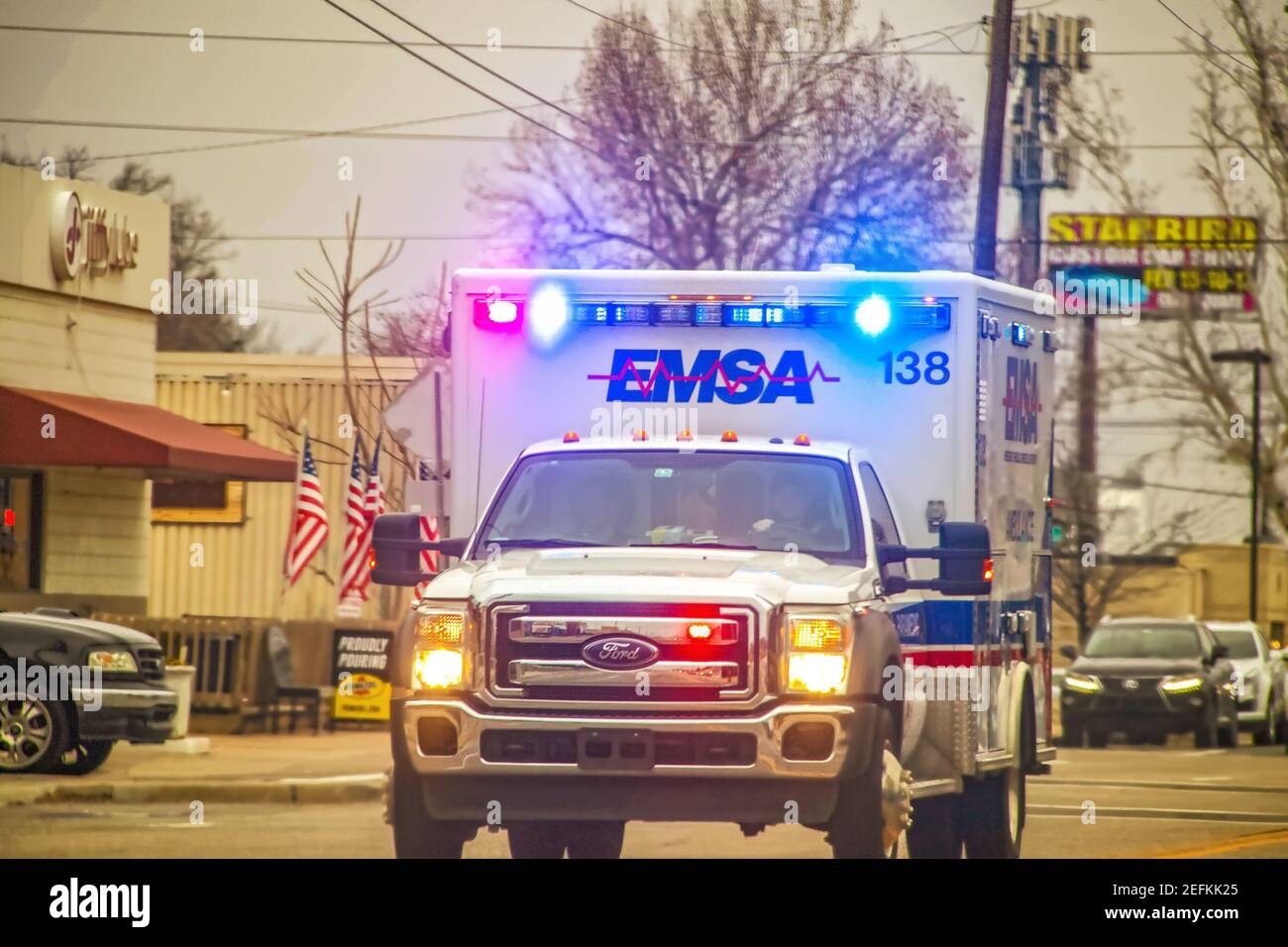 2-1-2019 Tulsa USA - in arrivo EMSA ambulanza con luci che brillano sulla strada urbana in overcast giorno - fuoco selettivo Foto Stock