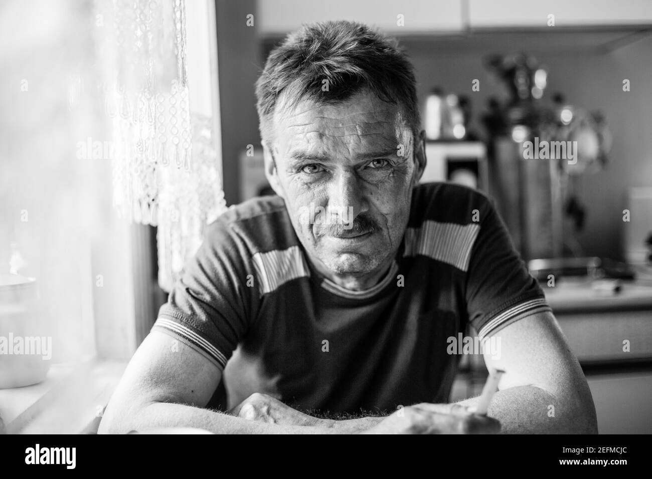 Ritratto di un uomo contadino nella sua casa rurale. Foto in bianco e nero. Foto Stock
