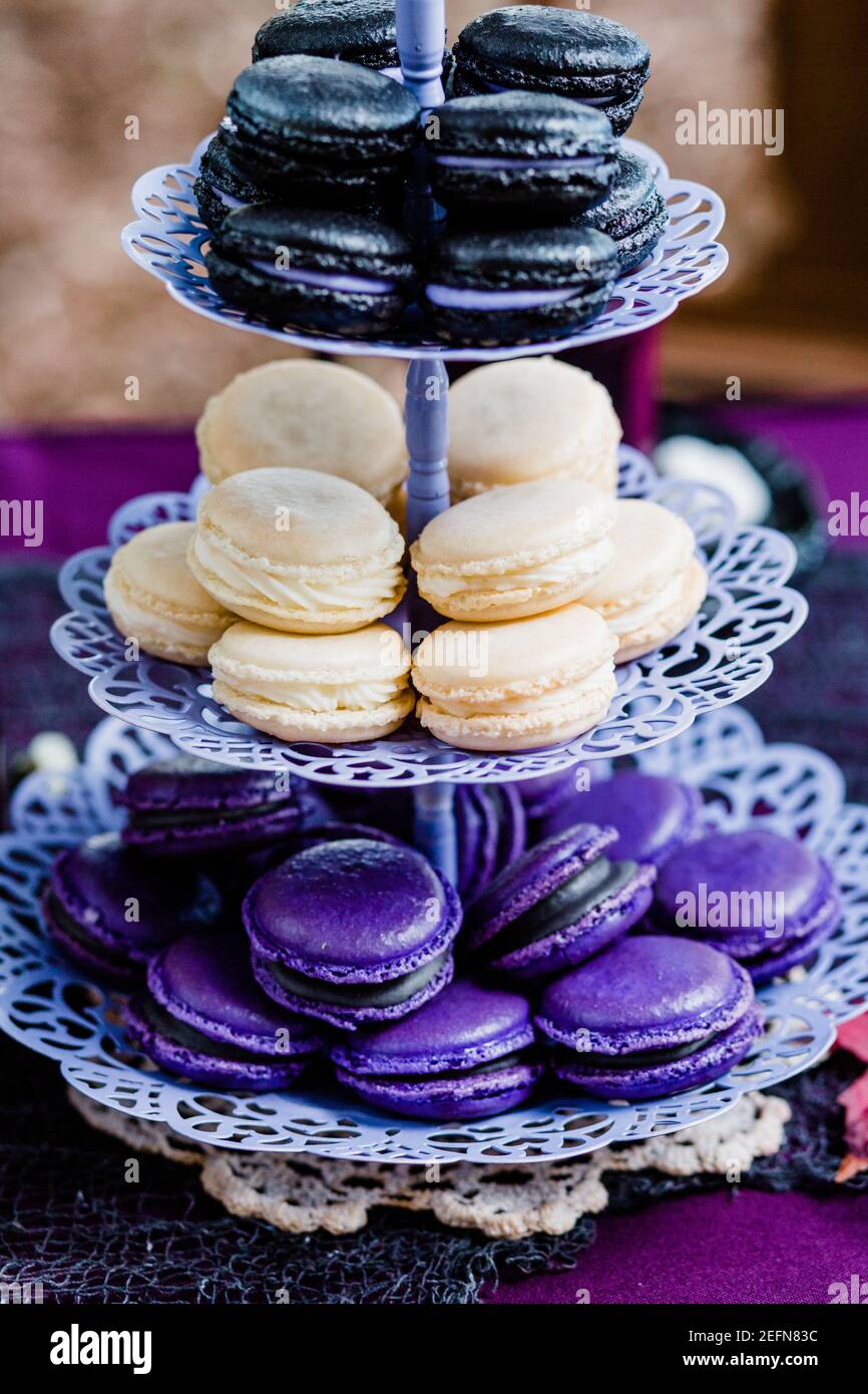Macarons colorati su un vassoio di servizio in jewel toni per Dessert spooky Foto Stock