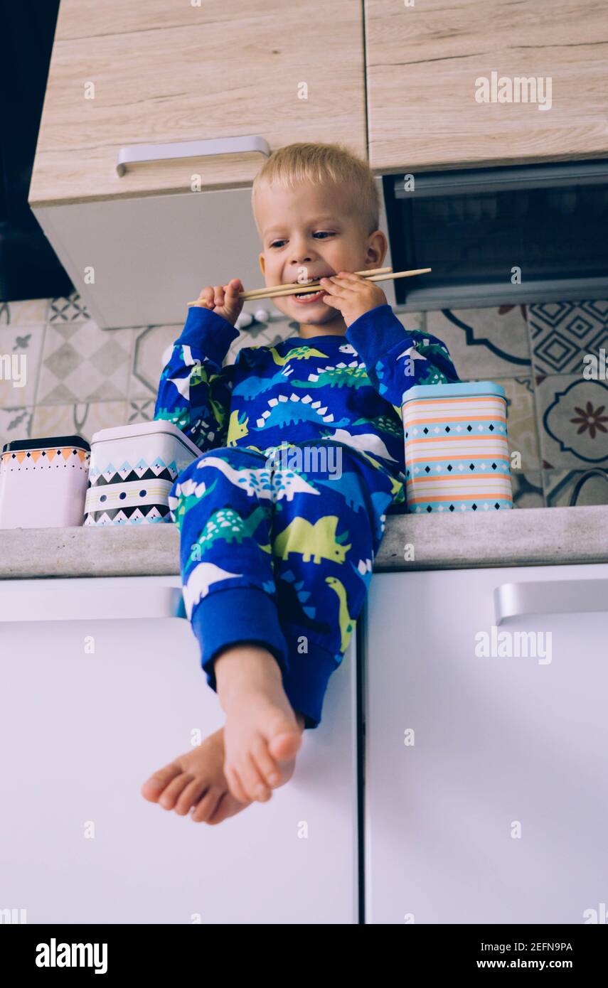 Il bambino gioca in cucina al mattino Foto Stock