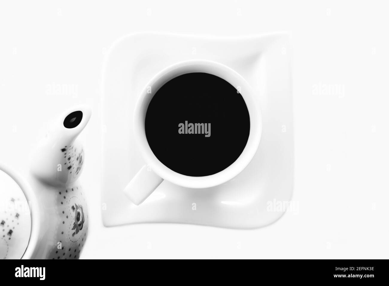 Una tazza di tè o caffè su sfondo bianco, vista dall'alto. Fotografia bianco-nero Foto Stock