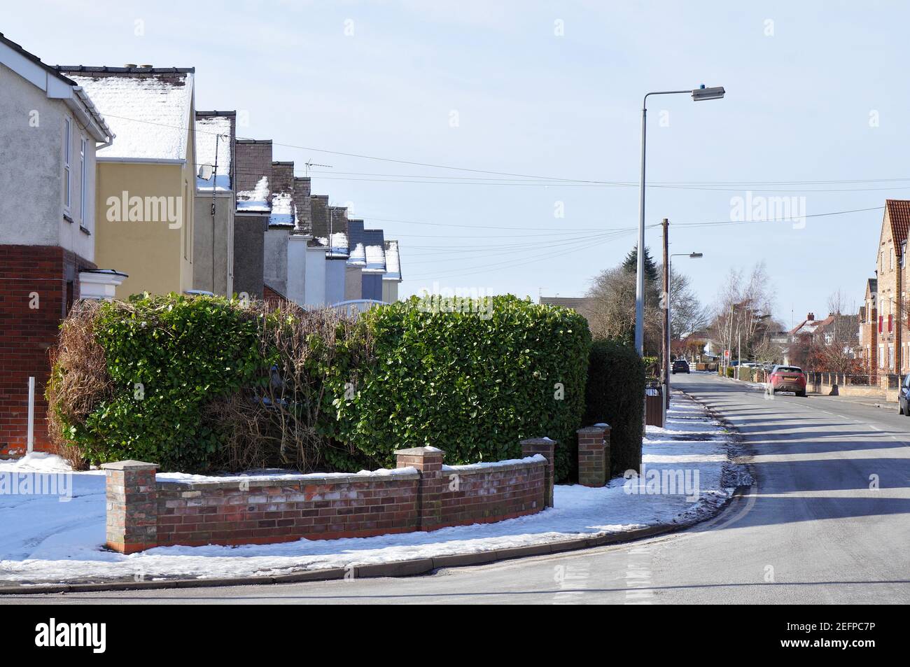 Guardando verso Wyberton West Rd. Con una fila di case innevate in un pomeriggio soleggiato in inverno. Foto Stock
