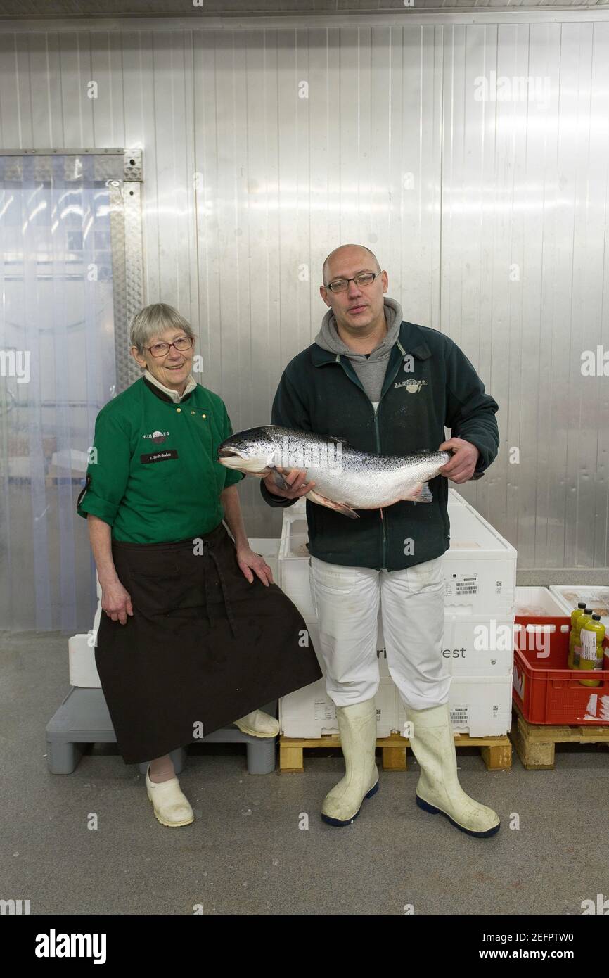 Pescivendoli che tengono un grande salmone Atlantico nel suo posto di lavoro Città anseatica di Brema, Germania . Foto Stock