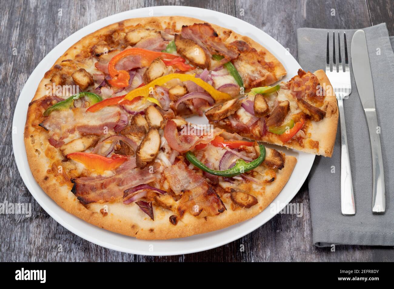 Una pizza di festa della carne con una fetta rimossa vista da sopra Foto Stock