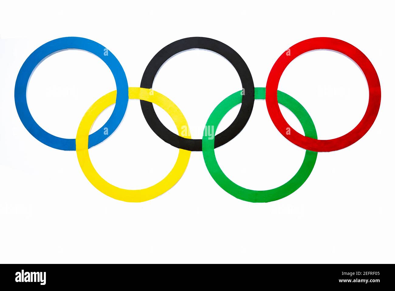 Cinque anelli intrecciati in blu, nero, rosso, giallo e verde su sfondo bianco Foto Stock