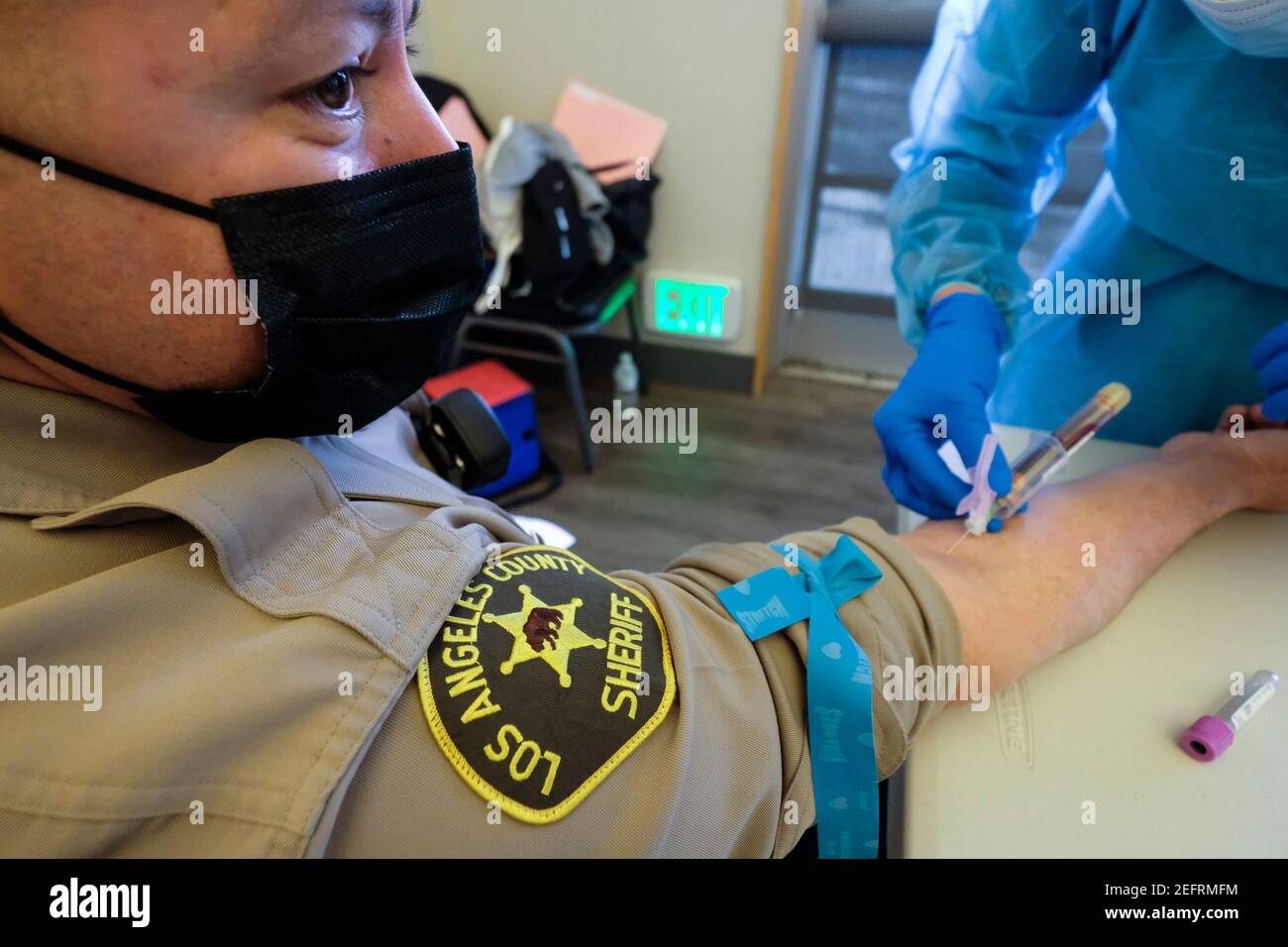 Los Angeles, California, Stati Uniti. 17 Feb 2021. Un operatore sanitario preleva il sangue da un ufficiale dello sceriffo della contea di Los Angeles durante un test di anticorpi No-Cost COVID-19 tenuto dalla città di Pico Rivera e dal senatore del 32° distretto, Bob Archuleta collabora con la Fondazione GUARDaHEART, al Pico Park di Pico Rivera, California, il 17 febbraio 2021. Credit: Ringo Chiu/ZUMA Wire/Alamy Live News Foto Stock