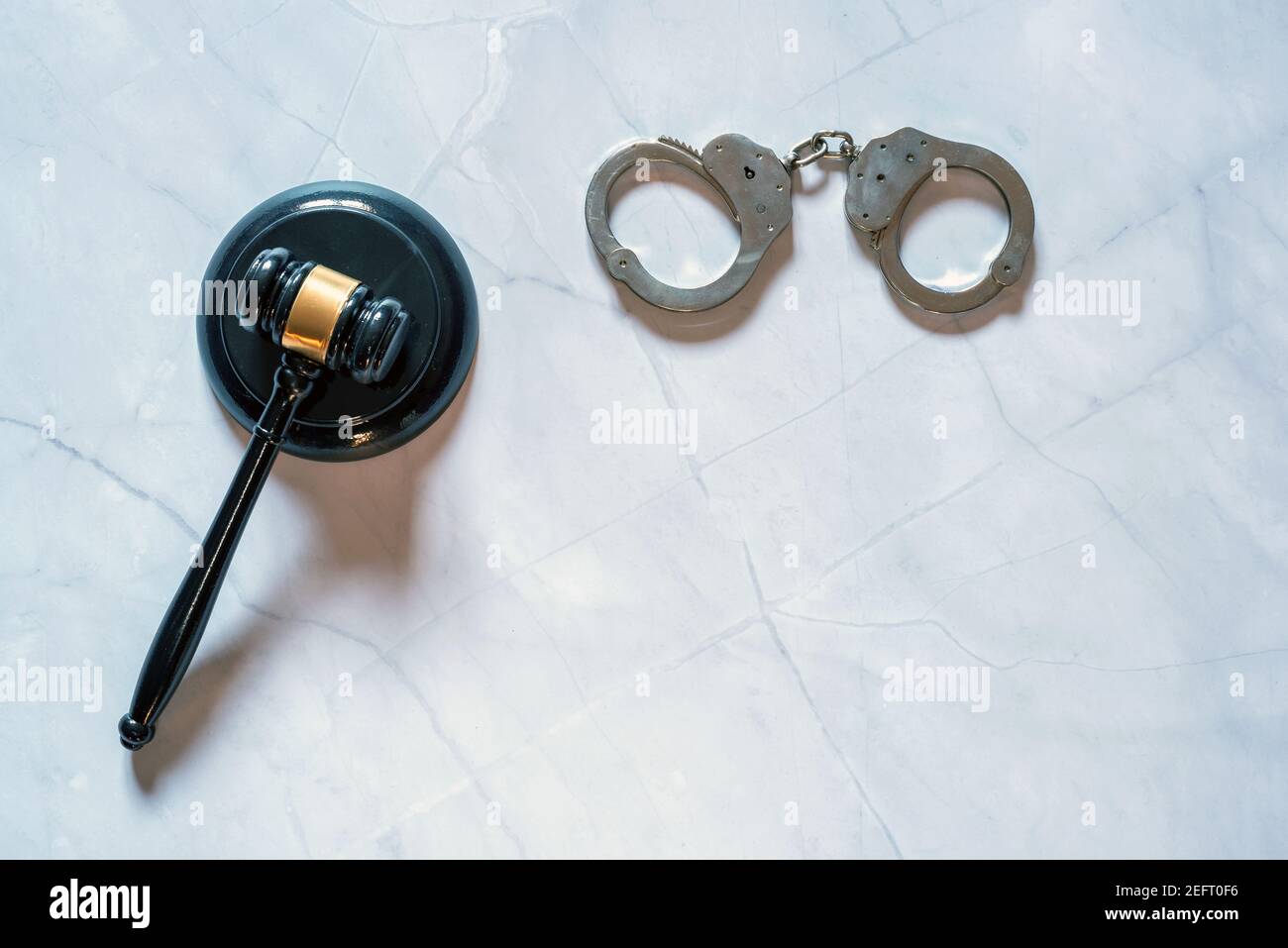 su una pietra di marmo bianco si trova il martello e le manette di un giudice. Foto Stock