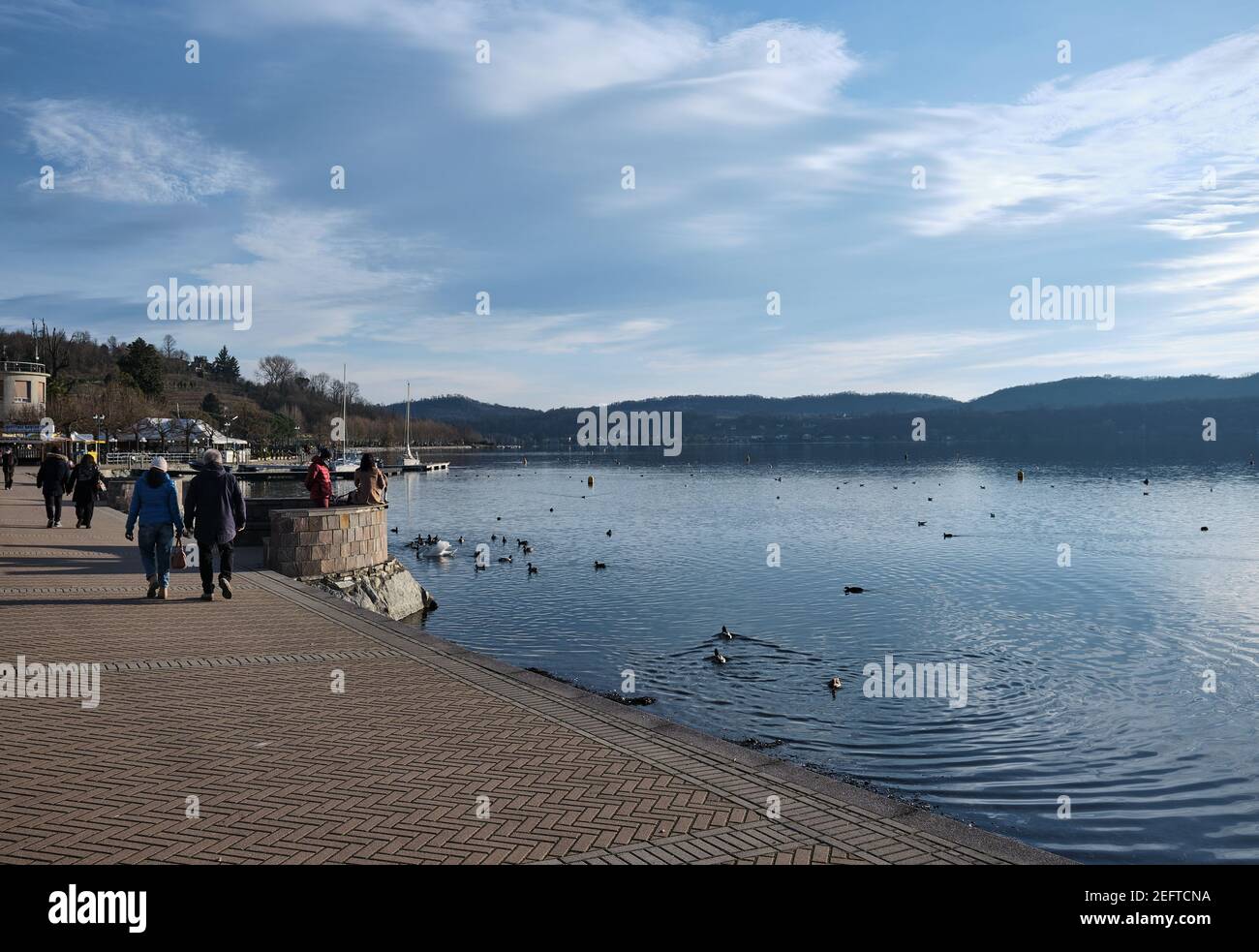 Lago di Viverone - febbraio 2021: In primavera si passeggia lungo il molo di un lago alpino Foto Stock