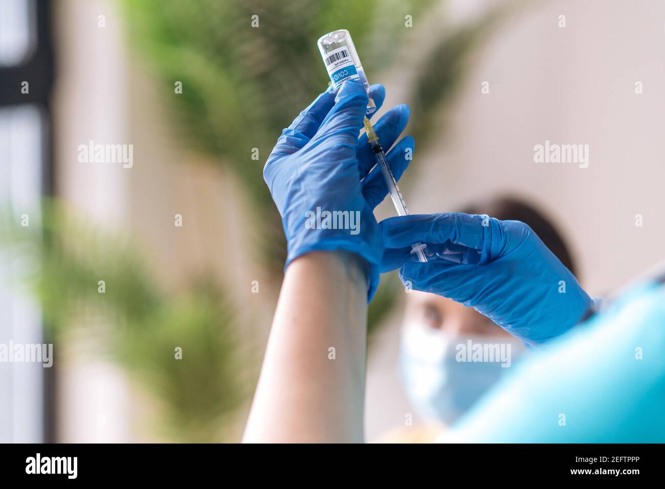 Mani del medico o dell'infermiere che indossano guanti medici che tengono la siringa e la fiala con l'iniezione di vaccino del virus della corona COVID-19. Cura del coronavirus, concetto di prevenzione covid-19 Foto Stock