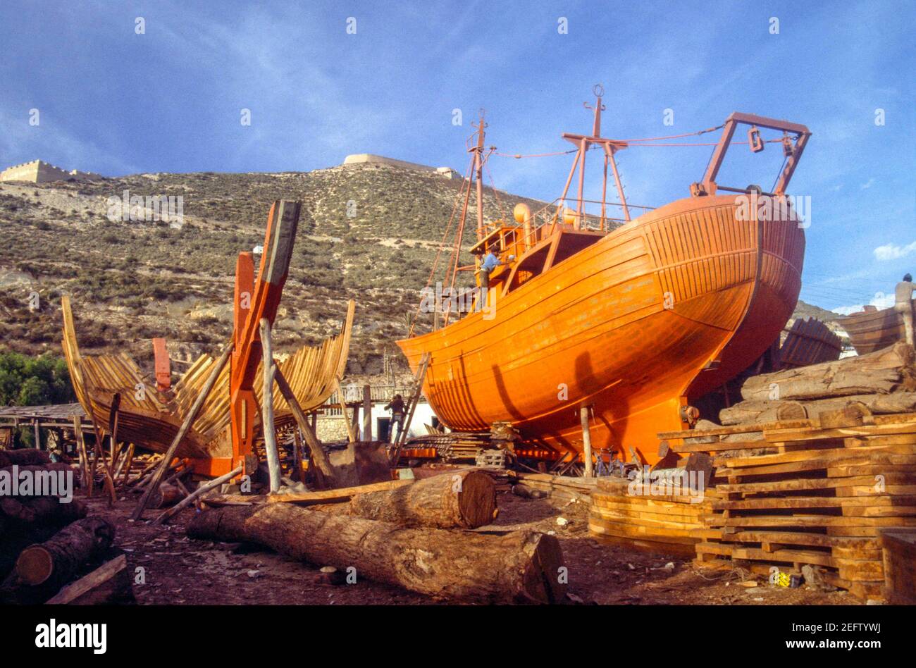 Costruzione di barche in Agadir, Marocco, 1987. Le imbarcazioni in  costruzione sono innavvitate con vernice al piombo rossa Foto stock - Alamy