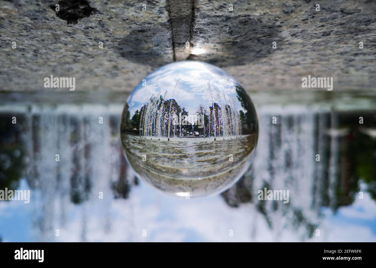 Grande fontana della città riflessa in cristallo vetro palla Foto Stock