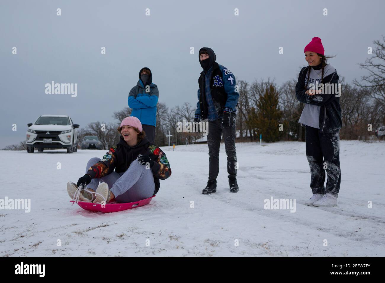 Fiore Mound, Texas, Stati Uniti. 17 Feb 2021. 2/17/21, Flower Mound, Texas - i texani hanno trovato il modo di trasformare questa tempesta invernale in un'esperienza divertente. Un gruppo di adolescenti trascorre la serata in slitta con i loro amici. Credit: Chris Rusanowsky/ZUMA Wire/Alamy Live News Foto Stock