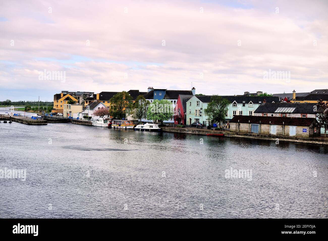 Athlone, Contea di Westmeath, Irlanda. Barche legate nel fiume Shannon lungo case e edifici in ordine. Foto Stock