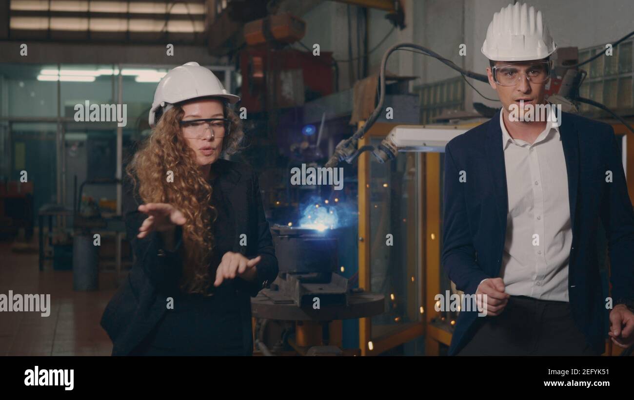 Felice industria pesante business engineering e manager in hardhats danza divertente insieme saldatura interna fabbrica industriale di produzione dopo le sucche Foto Stock