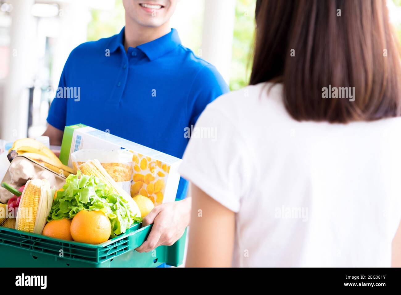 Uomo di consegna che consegna il cibo ad una donna - drogheria in linea concetto di servizio di shopping Foto Stock