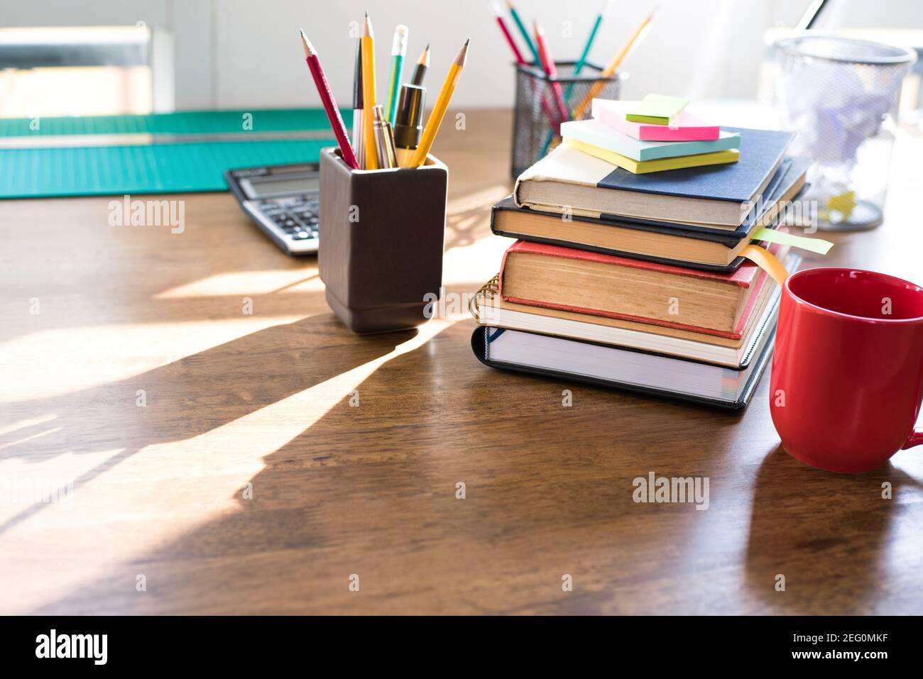 Pila di libri e cancelleria su tavola di legno Foto Stock