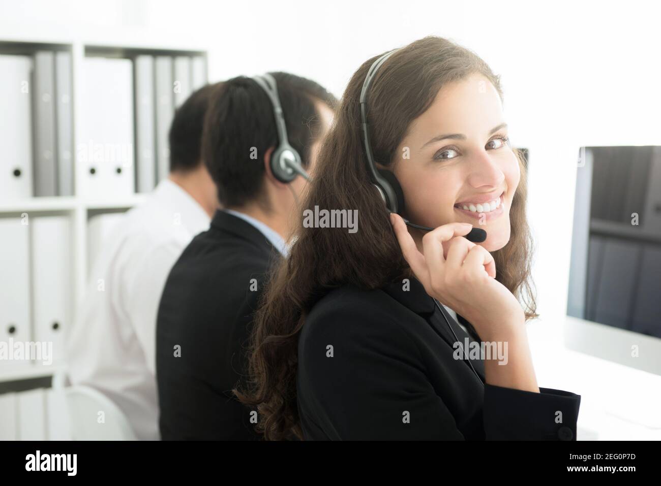Bella donna sorridente che lavora nel call center come operatore o il personale del servizio clienti Foto Stock