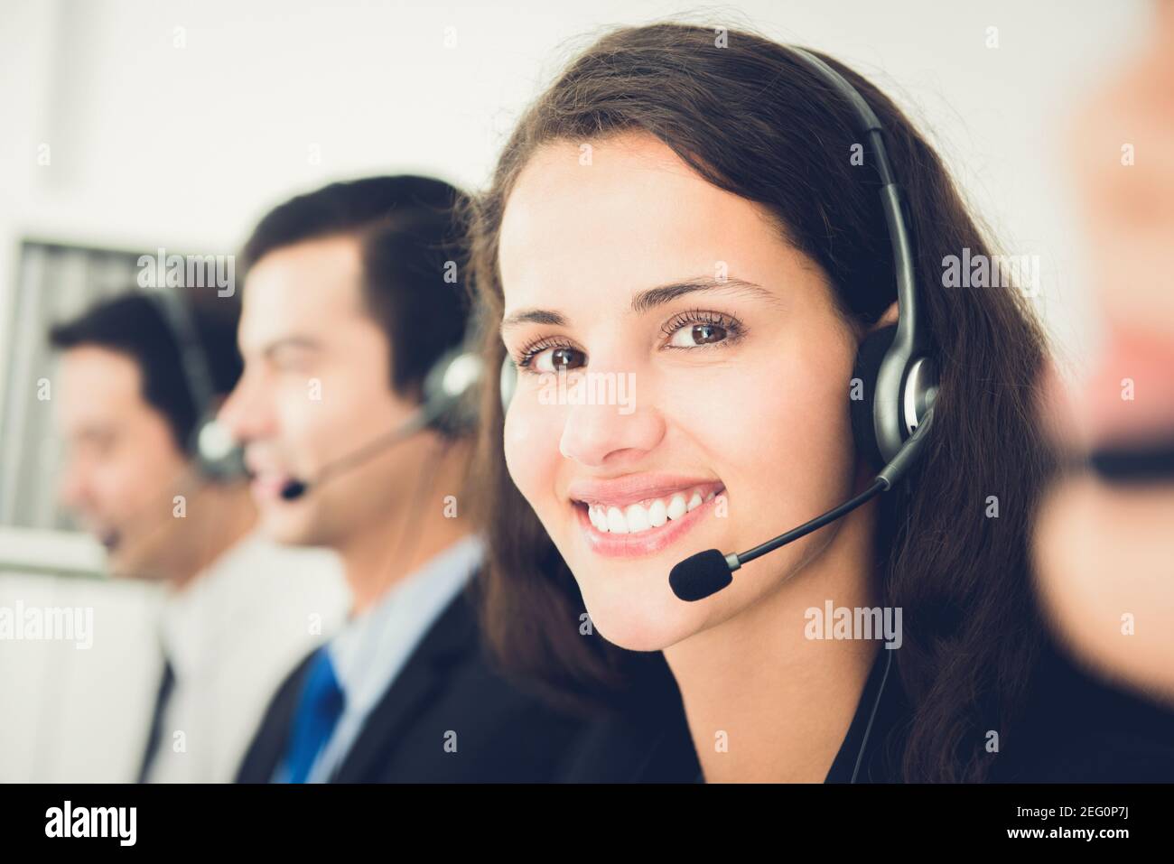 Bella donna sorridente che lavora nel call center come operatore o il personale del servizio clienti Foto Stock