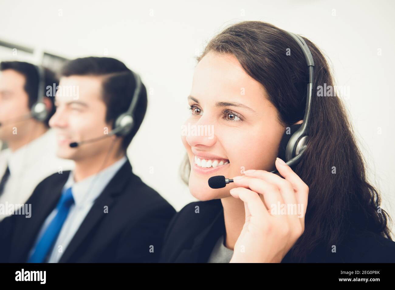 Bella donna sorridente che lavora nel call center come operatore o telemarketer Foto Stock