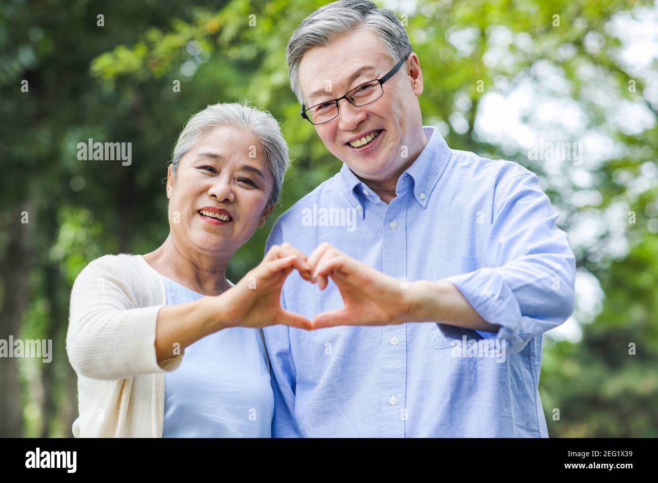 Ritratto di felice coppia vecchia con gesto del cuore Foto Stock
