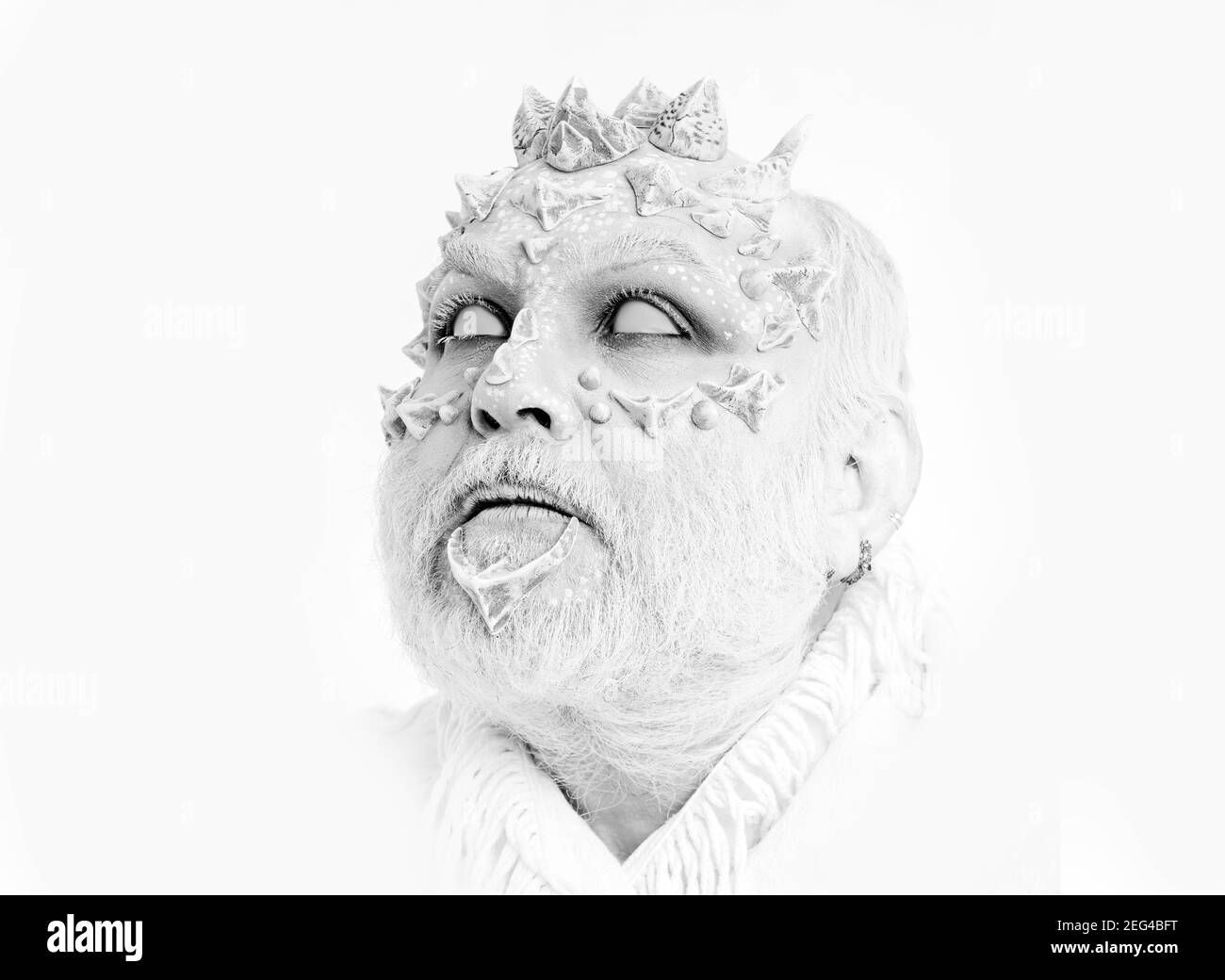 Diavolo con spine sul viso. Demone con barba argentata su sfondo bianco. Concetto di mistero e fantasia. Uomo con occhi ciechi che guardano in su. Procedura guidata con Foto Stock