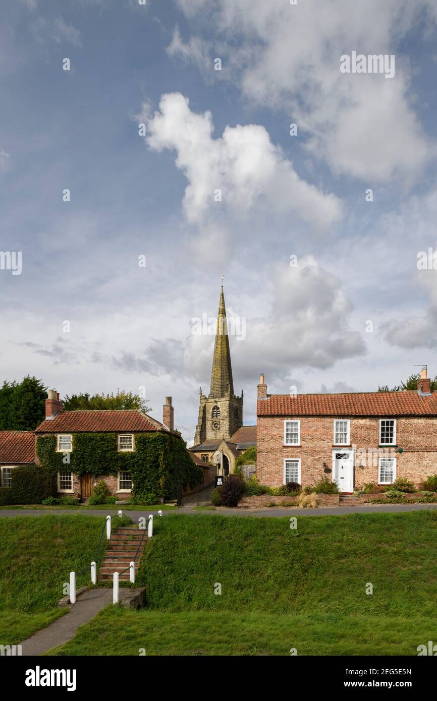 Historic St. Edith's Church (alta guglia), villaggio verde beck e pittoreschi cottage sotto il cielo blu - Bishop Wilton, East Riding of Yorkshire, Inghilterra, Regno Unito. Foto Stock